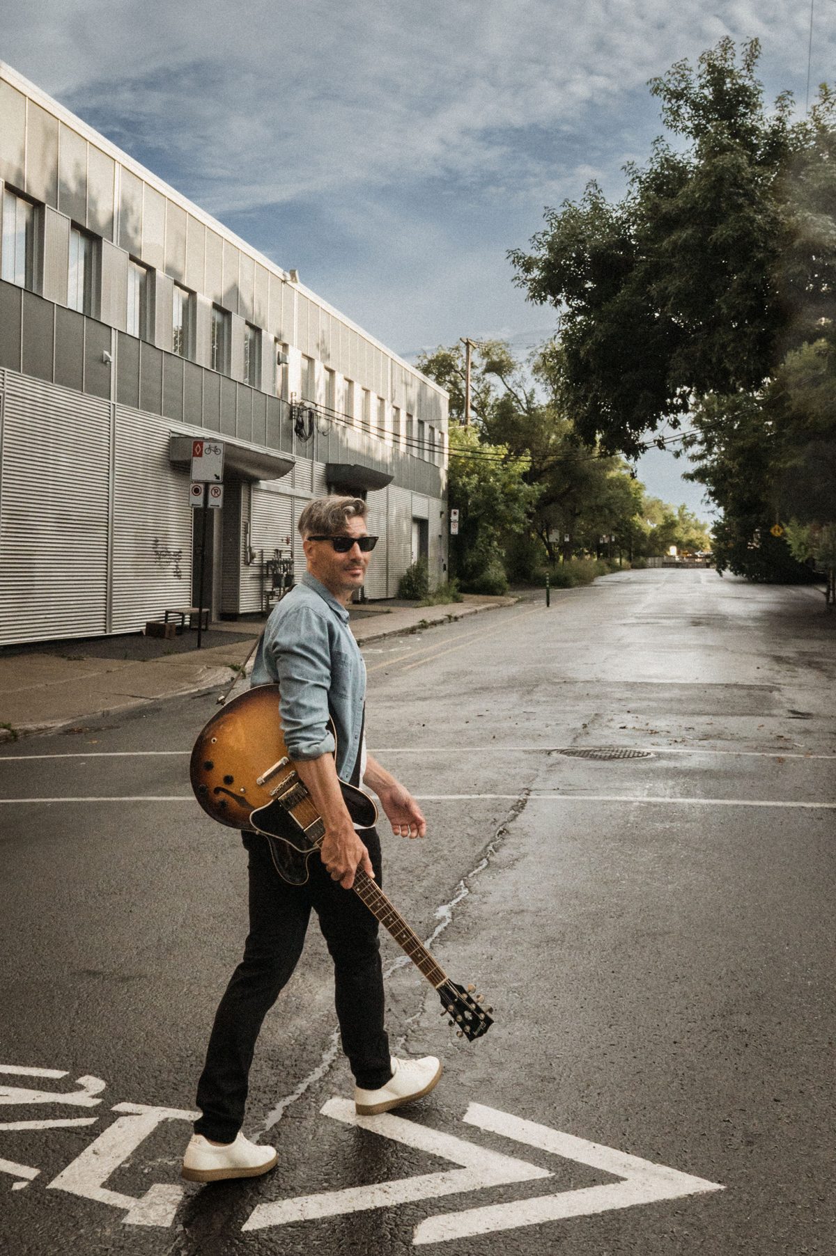 lepato traverse la rue avec sa guitare